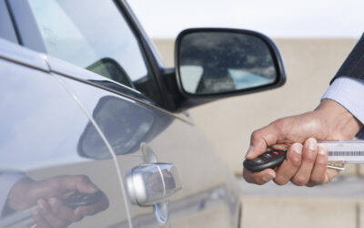 Hispanic businessman using electronic key to open car door